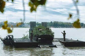 Ein Schützenpanzer übersetzt mit einer Schwimmfähre ein Wasserhindernis.(Foto: MoD Russia/gemeinfrei)